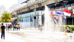 water fountain in front of flag poles near building