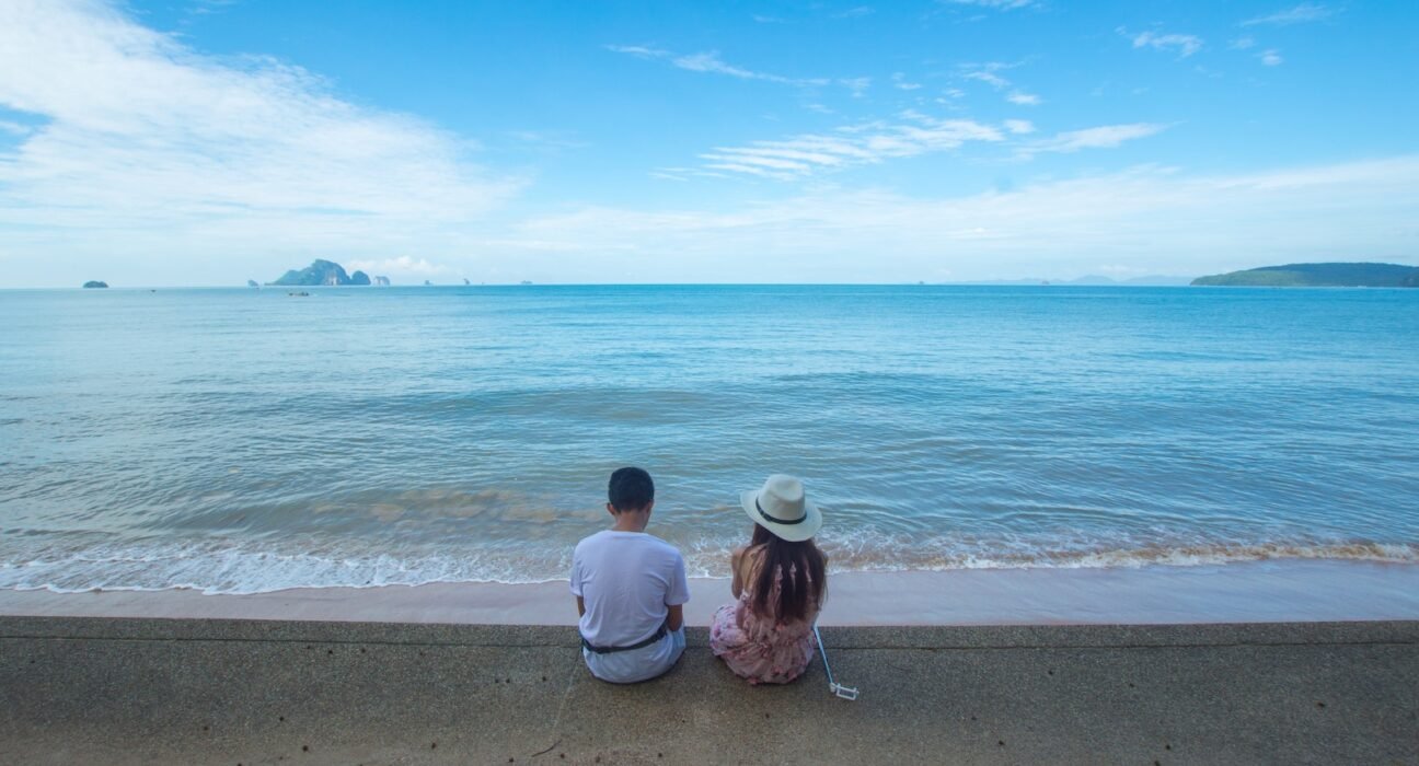 Man and Woman Sitting on Seashore