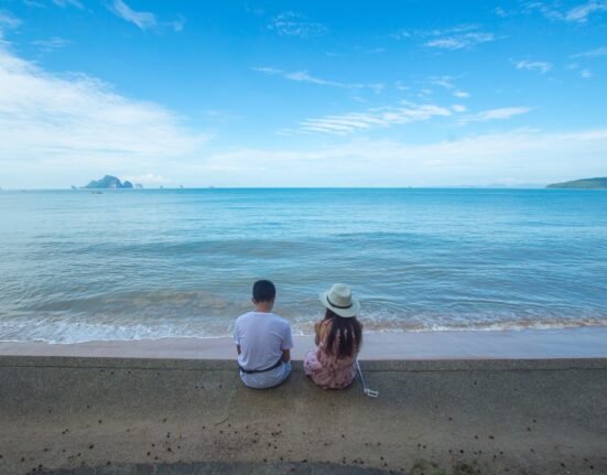 Man and Woman Sitting on Seashore