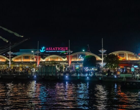 a night view of a restaurant on the water