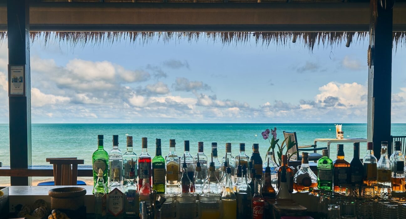 a bar with bottles of alcohol on the beach