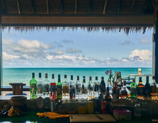 a bar with bottles of alcohol on the beach