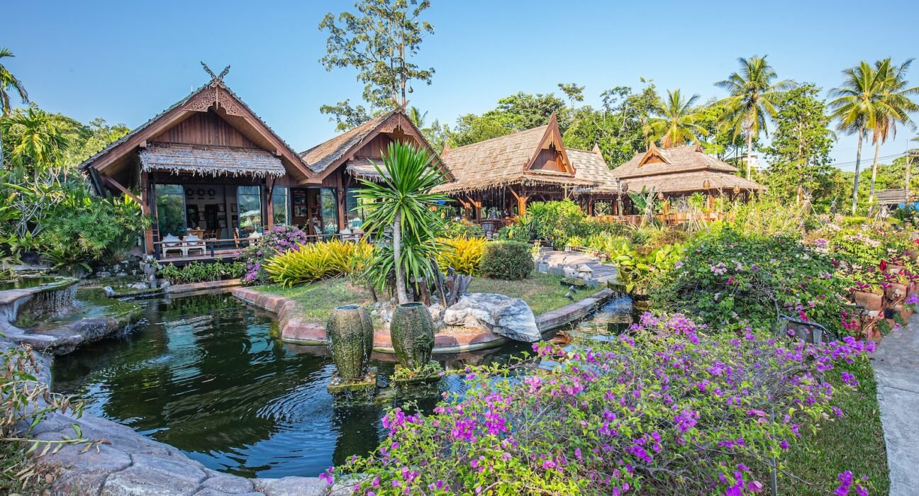 a garden with a pond surrounded by flowers