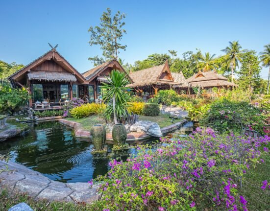 a garden with a pond surrounded by flowers