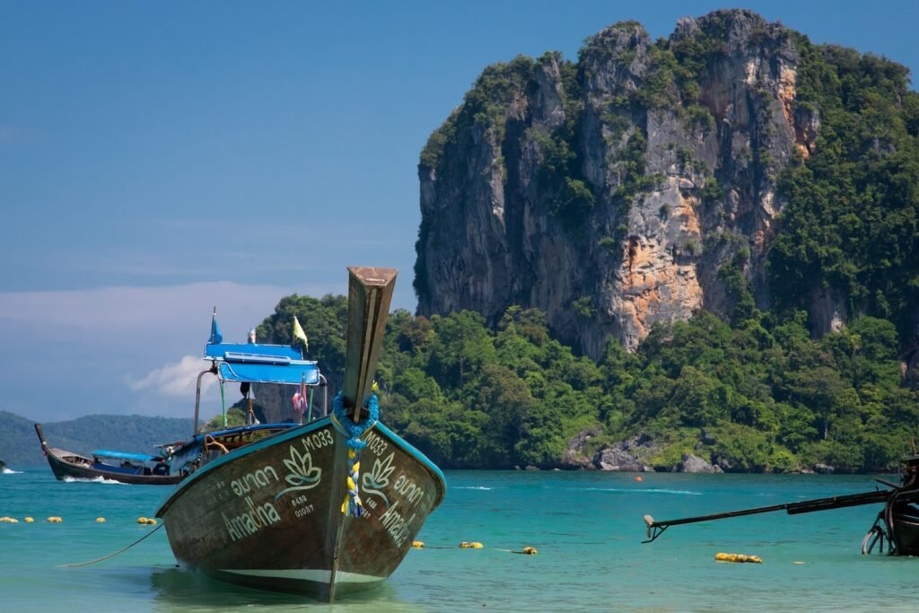 a boat in the water with Railay Beach in the background