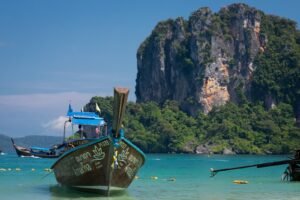 a boat in the water with Railay Beach in the background