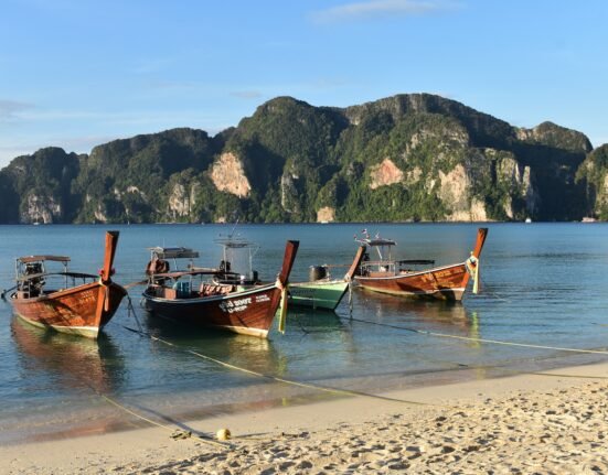 a couple of boats that are sitting in the sand