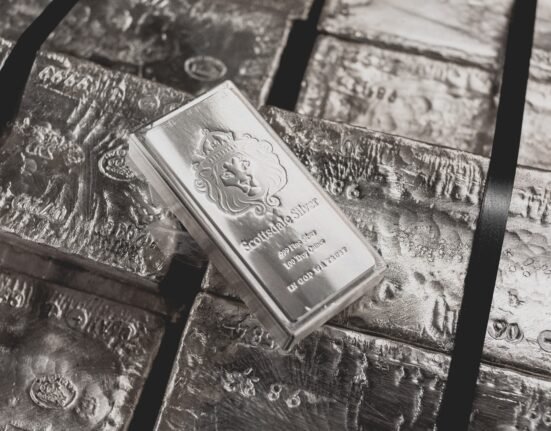 a scottsdale mint stacker bar sits on top of a pallet of raw silver.