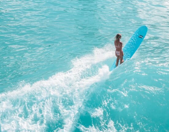 A Woman in a Bikini Surfing