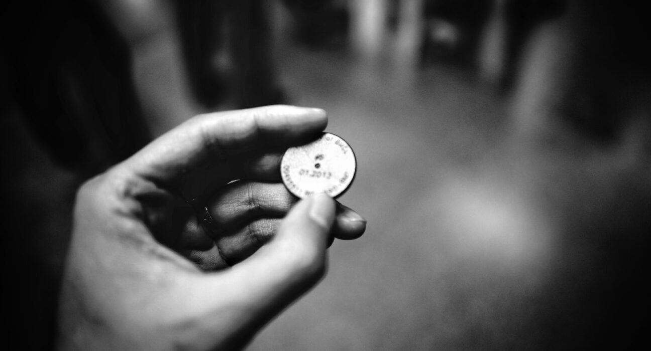 grayscale photography of person holding coin