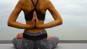 woman in black sports bra and black and white skirt sitting on white and black textile