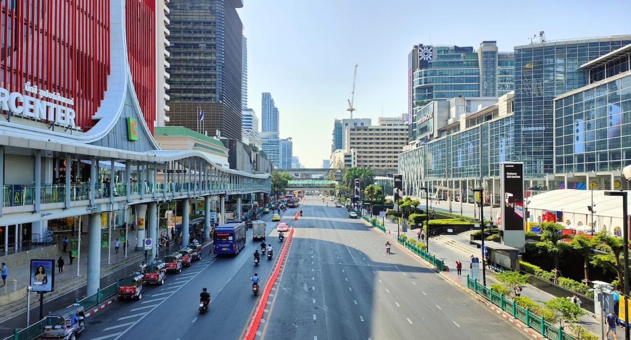 a city street filled with traffic next to tall buildings