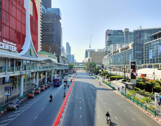 a city street filled with traffic next to tall buildings