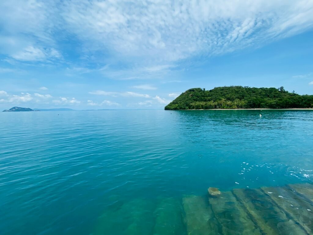 green island on blue sea under blue sky during daytime