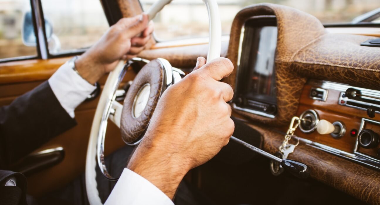 person holding vehicle steering wheel