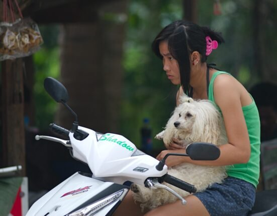 woman in pink tank top riding white and black motorcycle