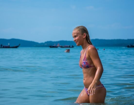 woman in bikini standing in water during daytime