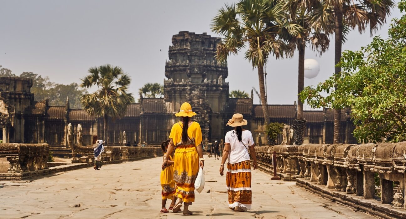 a couple of women walking across a stone walkway
