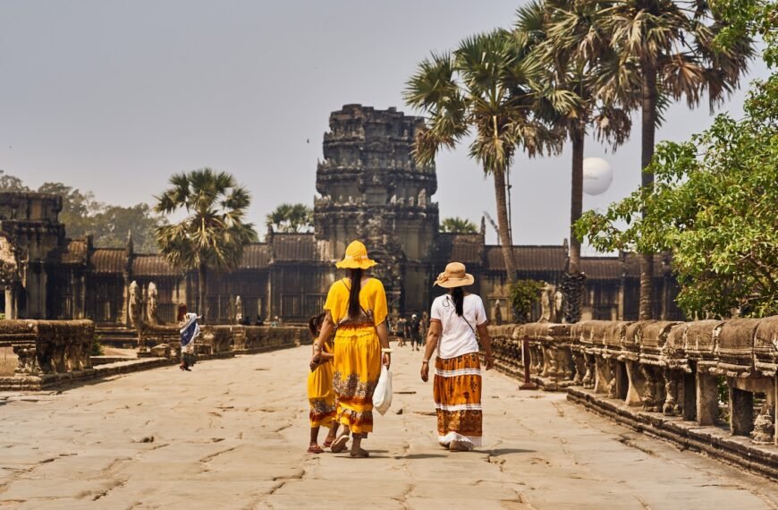 a couple of women walking across a stone walkway