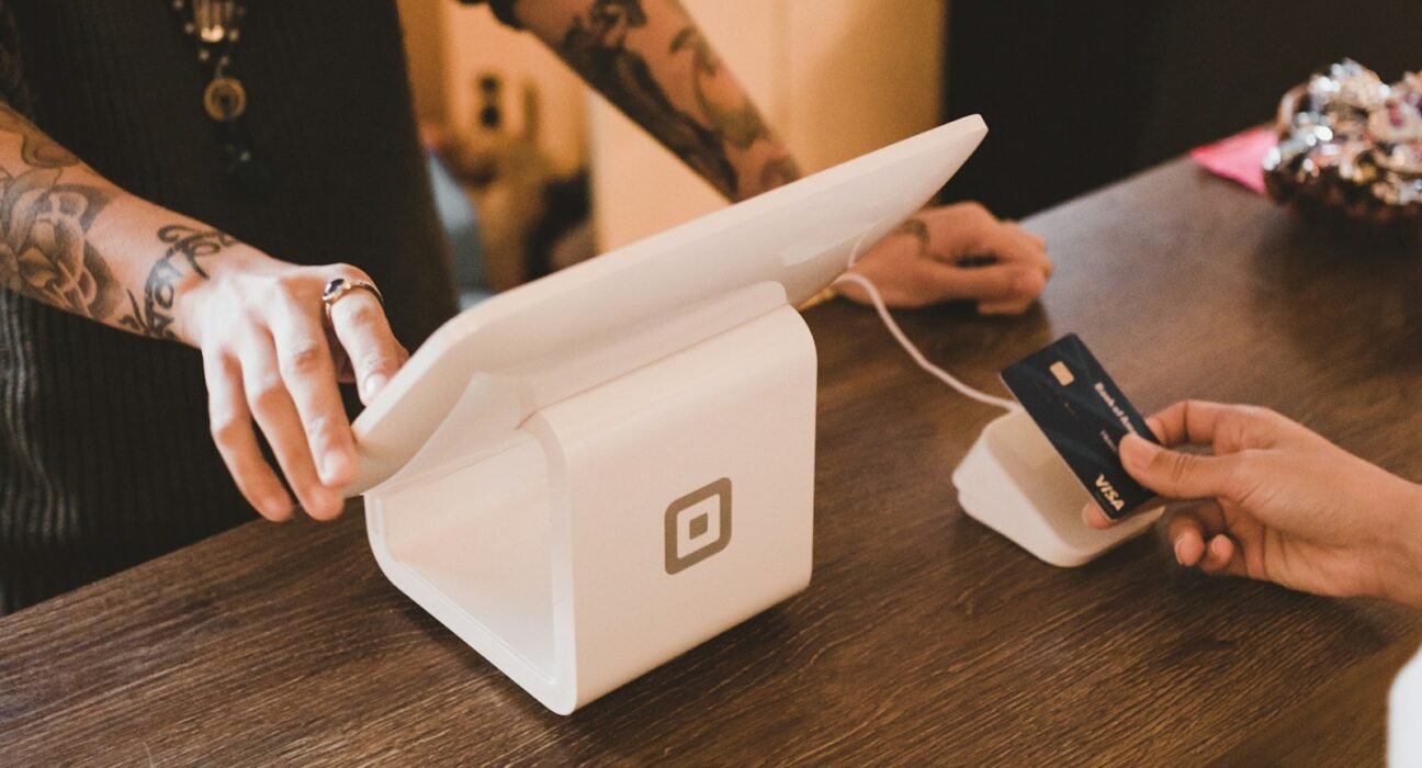 person holding white POS machine