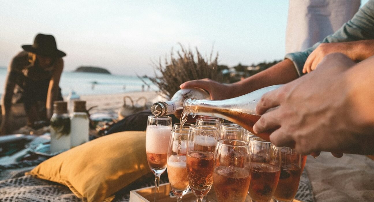 person pouring wine on clear drinking glass