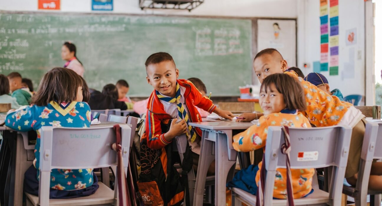 a group of children sitting at desks in a classroom