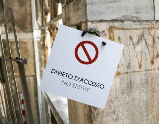 a no entry sign hanging on the side of a building