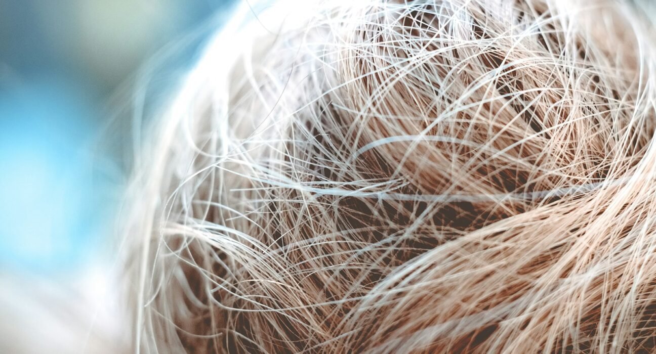a close up of a person's hair with a blurry background