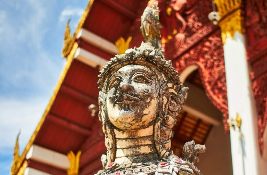 brown concrete statue under red and white roof