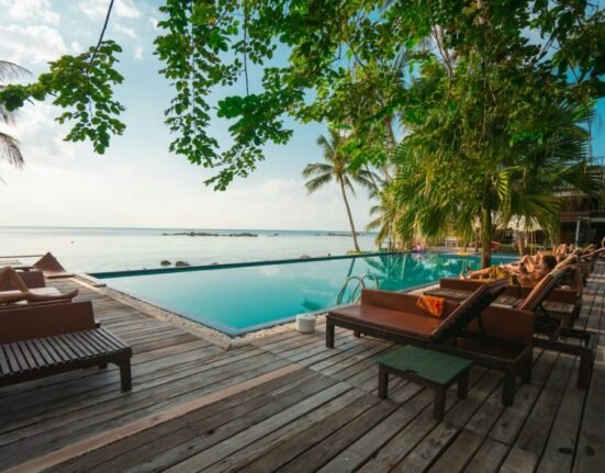 brown wooden table and chairs on brown wooden deck near body of water during daytime