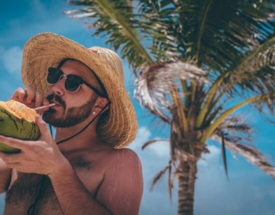 man standing holding green coconut during daytime
