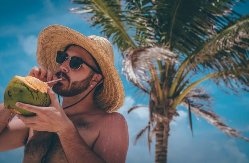 man standing holding green coconut during daytime