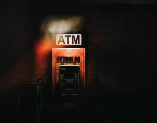 a building with a atm sign lit up at night