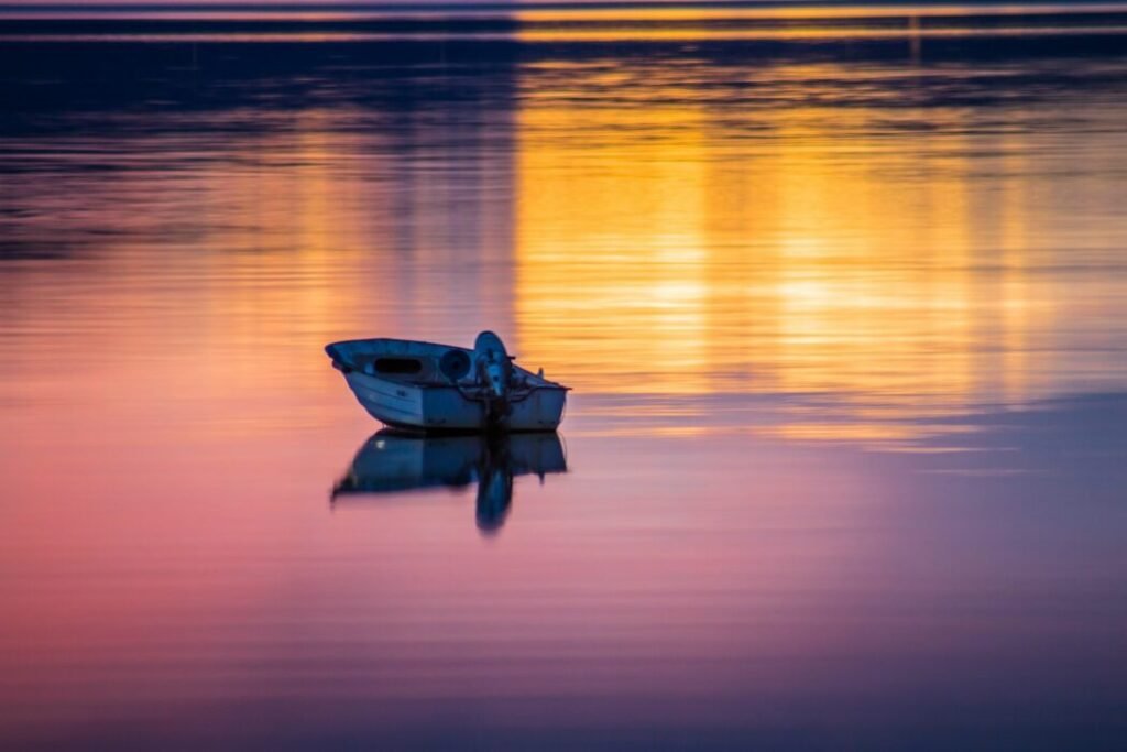 man riding on boat on sea during sunset