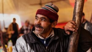 man in black leather jacket wearing red and white knit cap