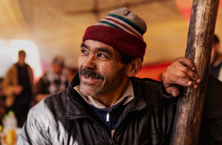 man in black leather jacket wearing red and white knit cap