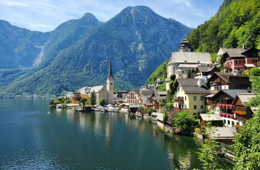 houses near body of water and mountain during daytime