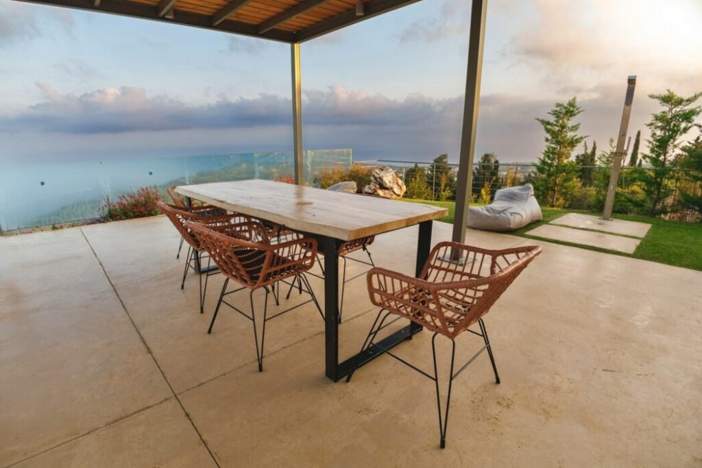 a table and chairs on a patio with a view of the ocean