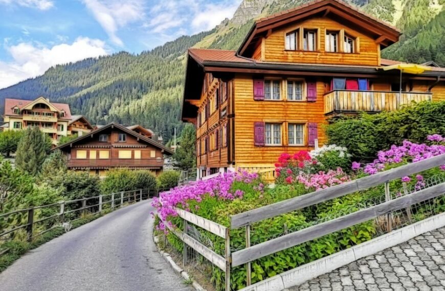 brown wooden house near purple flower field during daytime