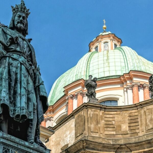 a statue stands in front of a domed building
