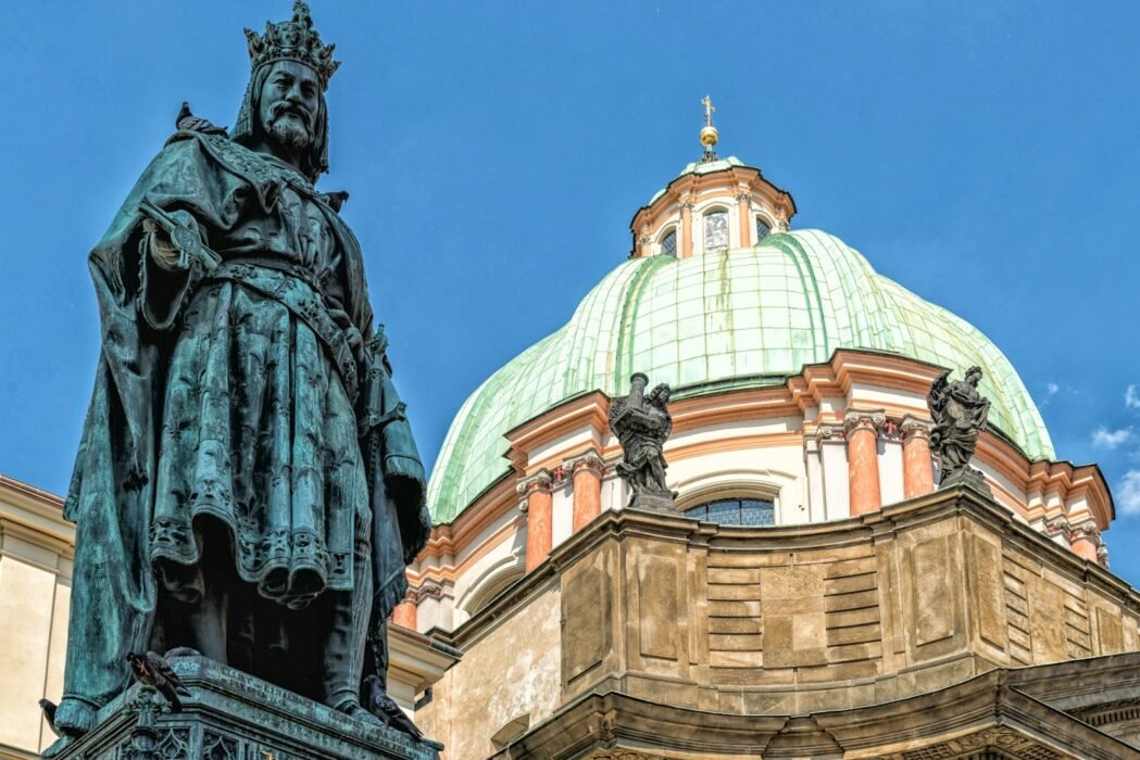 a statue stands in front of a domed building
